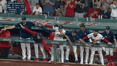 A Group Of Baseball Players Standing Behind A Green Xfinity Sign GIF