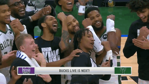 A Group Of Basketball Players Are Celebrating A Victory With A Banner That Says Bucks Live Is Next GIF