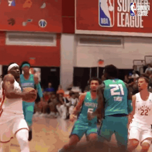 A Group Of Basketball Players Are Playing A Game In Front Of An Nba Sign GIF