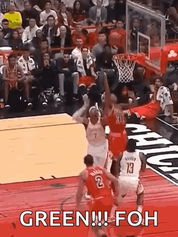 A Group Of Basketball Players Are Playing A Game Of Basketball And One Of Them Is Jumping For The Ball . GIF