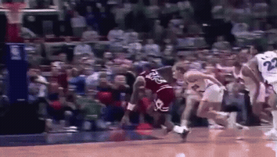 A Group Of Basketball Players Are Playing A Game Of Basketball On A Court In Front Of A Crowd . GIF