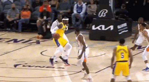 A Group Of Basketball Players Are Playing A Game Of Basketball On A Court In Front Of A Crowd . GIF