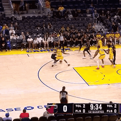 A Group Of Basketball Players Are Playing A Game Of Basketball On A Court With A Crowd Watching . GIF
