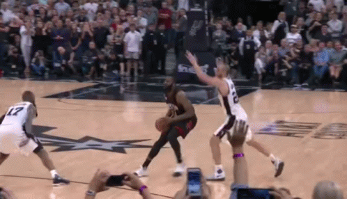 A Group Of Basketball Players Are Playing A Game On A Court With A Crowd Watching . GIF