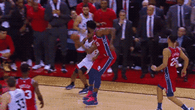 A Group Of Basketball Players Are Playing A Game On A Court With A Crowd Watching . GIF