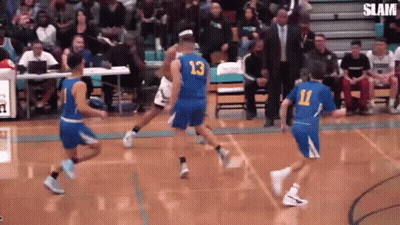 A Group Of Basketball Players Are Playing A Game On A Court With A Crowd Watching . GIF