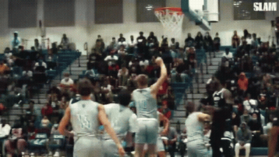 A Group Of Basketball Players Are Playing Basketball In Front Of A Crowd . GIF