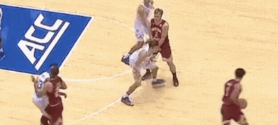 A Group Of Basketball Players Are Playing On A Court With A Banner That Says Acc On It . GIF