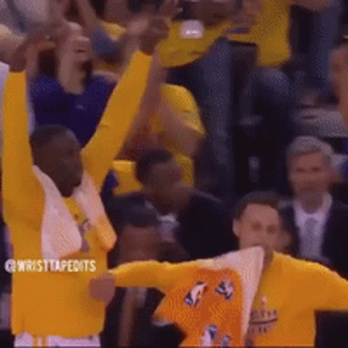 A Group Of Basketball Players Are Raising Their Arms In The Air . GIF