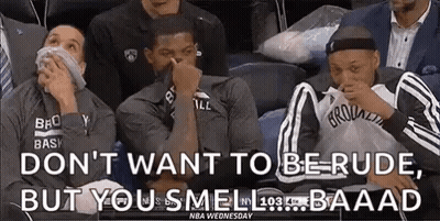 A Group Of Basketball Players Are Sitting In A Stadium Covering Their Noses . GIF