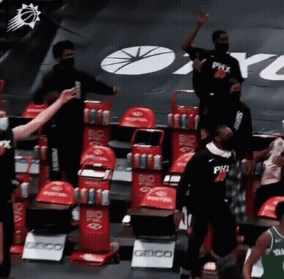 A Group Of Basketball Players Are Standing In A Stadium . GIF