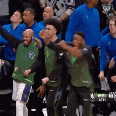 A Group Of Basketball Players Are Standing In A Stadium . GIF