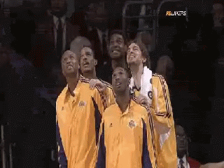 A Group Of Basketball Players Are Standing Next To Each Other In A Stadium . GIF