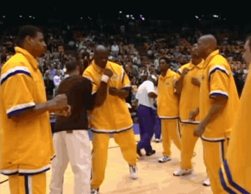 A Group Of Basketball Players Are Standing On A Court Wearing Yellow Jerseys With The Letter L On Them GIF