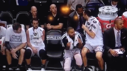 A Group Of Basketball Players Sitting On A Bench With One Wearing A Jersey That Says World Cup On It GIF