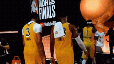 A Group Of Basketball Players Standing In Front Of A Sign That Says Finals GIF