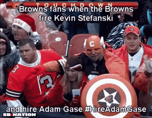 A Group Of Browns Fans Sitting In A Stadium With A Captain America Shield GIF