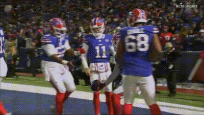 A Group Of Buffalo Bills Football Players Are Standing On The Field . GIF