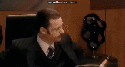 A Group Of Business People Are Sitting Around A Table In A Conference Room Having A Meeting . GIF