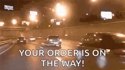 A Group Of Cars Are Driving Down A Highway At Night With The Words `` Your Order Is On The Way '' . GIF