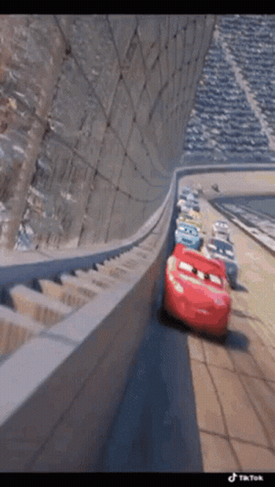 A Group Of Cars Are Driving Down A Race Track . GIF