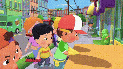 A Group Of Cartoon Characters Are Walking Down A Street With Disney Junior Written On The Bottom Right GIF