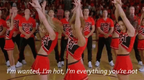 A Group Of Cheerleaders Are Dancing In A Gym And One Cheerleader Is Saying I 'M Wanted GIF