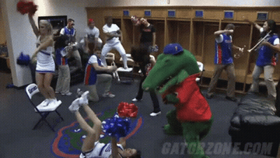 A Group Of Cheerleaders Are Dancing In A Locker Room With Gatorzone.com Written On The Bottom GIF