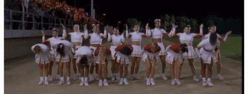 A Group Of Cheerleaders Are Posing For A Picture With Their Arms In The Air GIF