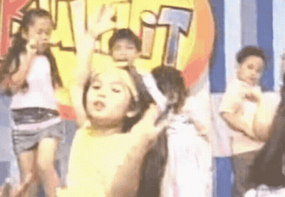 A Group Of Children Are Dancing On A Stage In Front Of A Sign That Says Visit . GIF