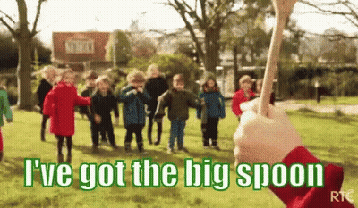 A Group Of Children Are Playing In A Park With A Person Holding A Big Spoon In Front Of Them . GIF