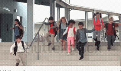 A Group Of Children Are Running Down The Stairs Of A School Building Holding Hands . GIF