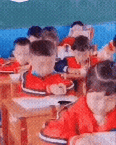 A Group Of Children Are Sitting In A Classroom . GIF