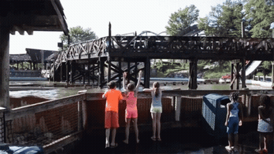 A Group Of Children Are Standing In Front Of A Bridge That Says ' A ' On It GIF