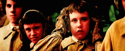 A Group Of Children Are Standing Next To Each Other In A Dark Room . GIF