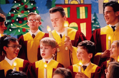 A Group Of Children Singing In A Choir With Candles In Their Hands GIF