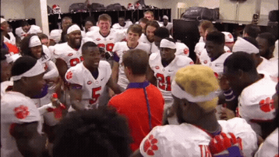 A Group Of Clemson Football Players Huddle Together In The Locker Room GIF
