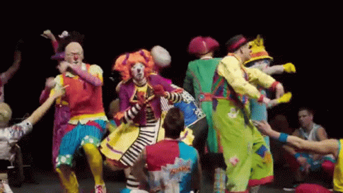 A Group Of Clowns Are Dancing Together On Stage GIF
