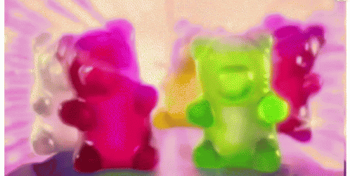 A Group Of Colorful Gummy Bears On A Table GIF