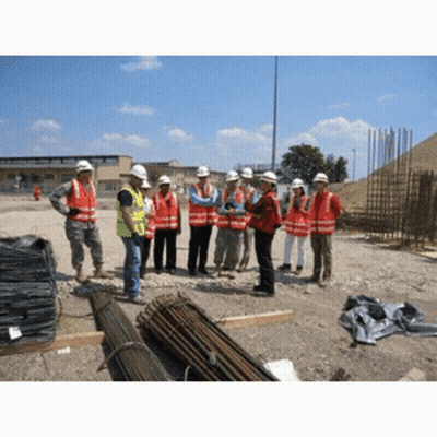 A Group Of Construction Workers Wearing Hard Hats Are Standing In A Dirt Field GIF