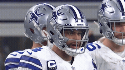 A Group Of Cowboys Players Standing In A Huddle GIF
