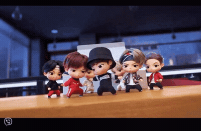 A Group Of Dolls Are Standing On A Table And One Of Them Is Wearing A Hat GIF