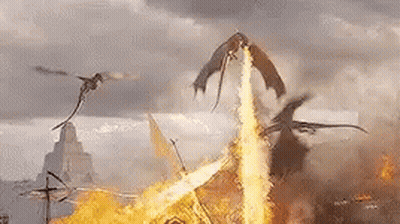 A Group Of Dragons Are Flying Over A Pile Of Fire . GIF