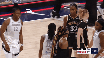 A Group Of Female Basketball Players Are Standing On A Court With One Wearing A Jersey That Says Washington GIF