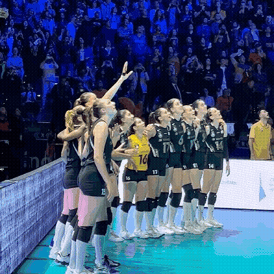 A Group Of Female Volleyball Players Standing On A Court With One Wearing A Yellow Jersey With The Number 14 On It GIF