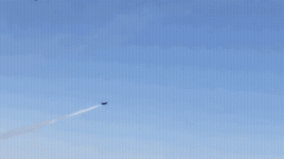 A Group Of Fighter Jets Are Flying In Formation In A Blue Sky GIF