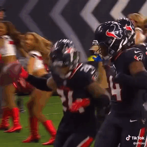 A Group Of Football Players Are Celebrating A Touchdown On A Field . GIF