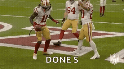 A Group Of Football Players Are Celebrating A Touchdown On A Football Field . GIF