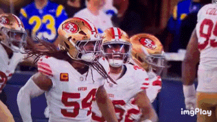 A Group Of Football Players Are Celebrating A Touchdown . GIF