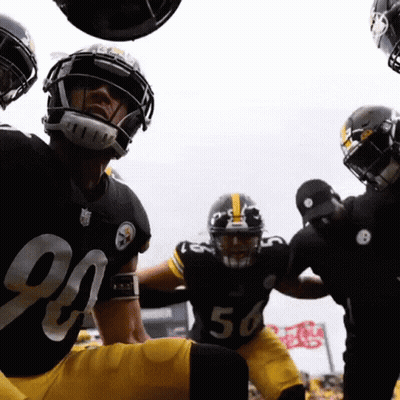 A Group Of Football Players Are Huddled Together And One Of Them Has The Number 56 On His Jersey GIF